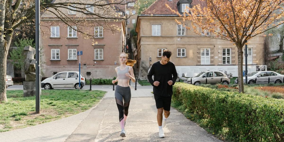 A couple jogging together in an urban park, enjoying outdoor exercise.