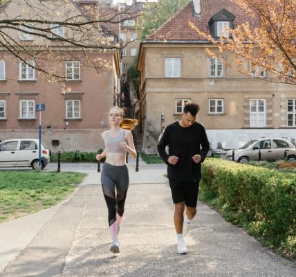A couple jogging together in an urban park, enjoying outdoor exercise.